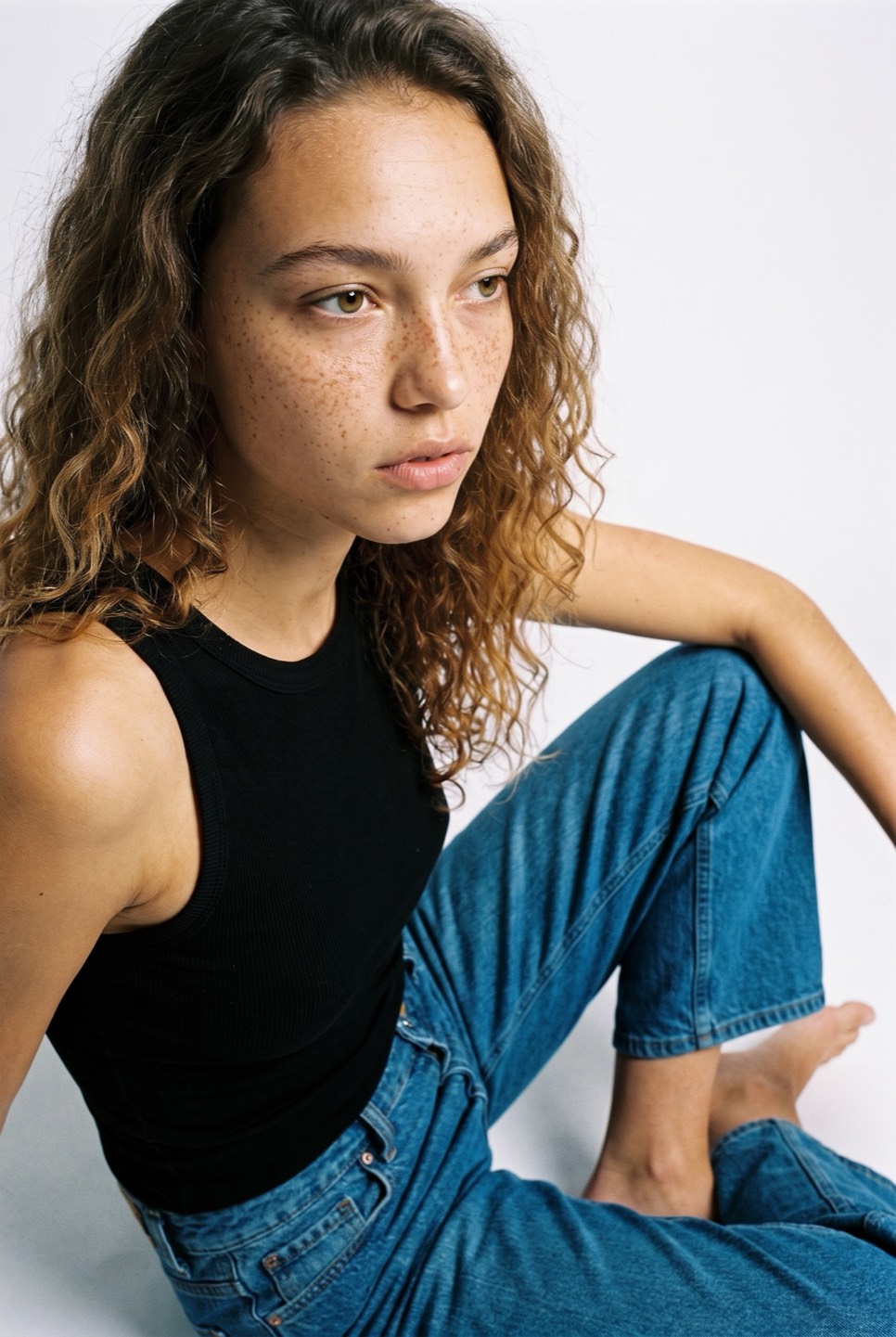 Synthetic talent, curly hair, seated — not a real person
