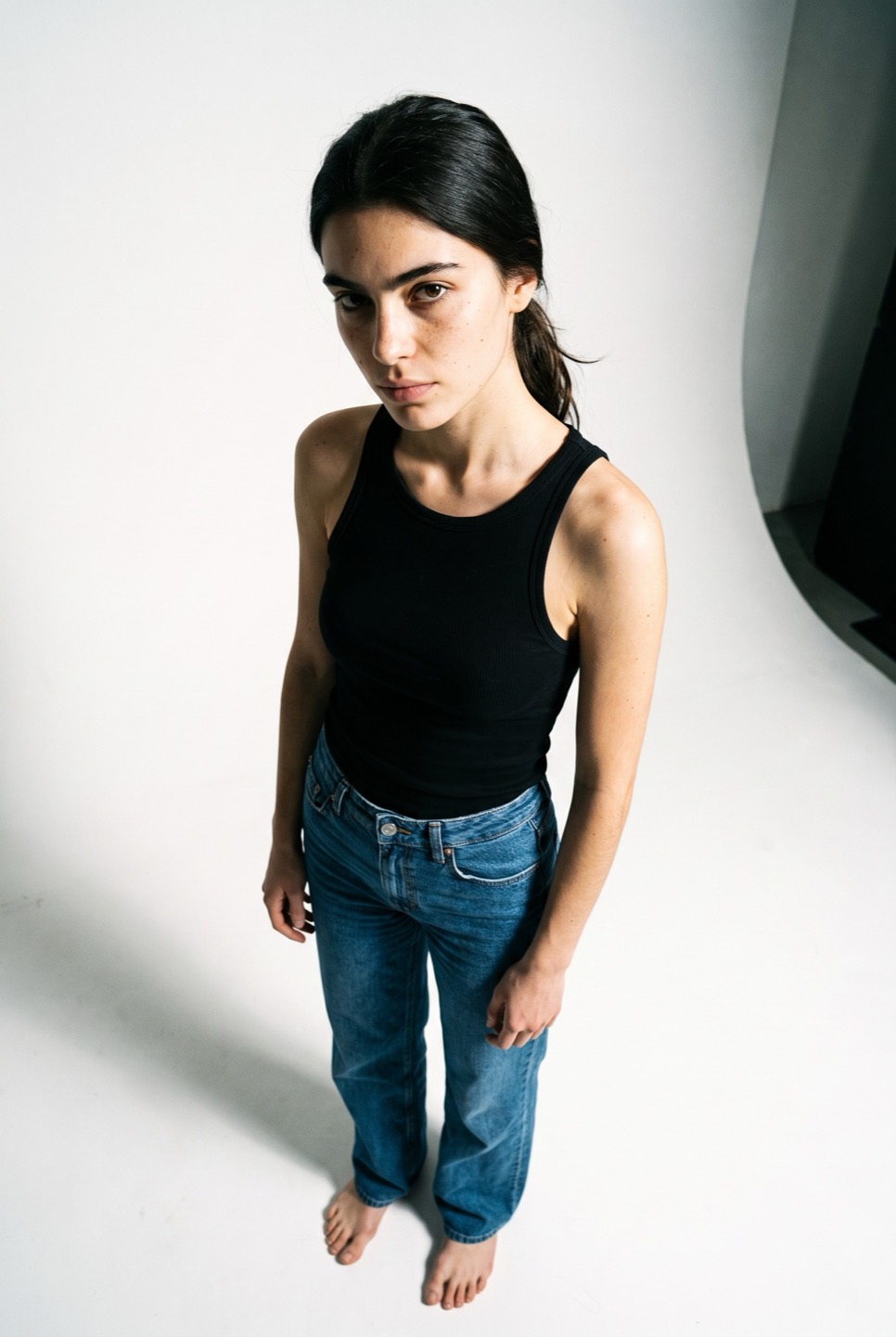 Synthetic talent, dark hair tied back, shot from above — not a real person
